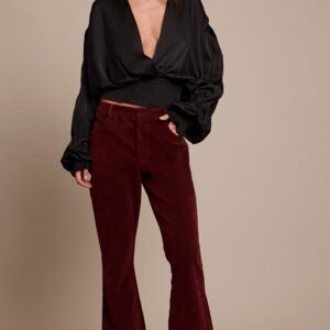 بلوزة ستان سوداء بكشكش وفتحة صدر عميقة